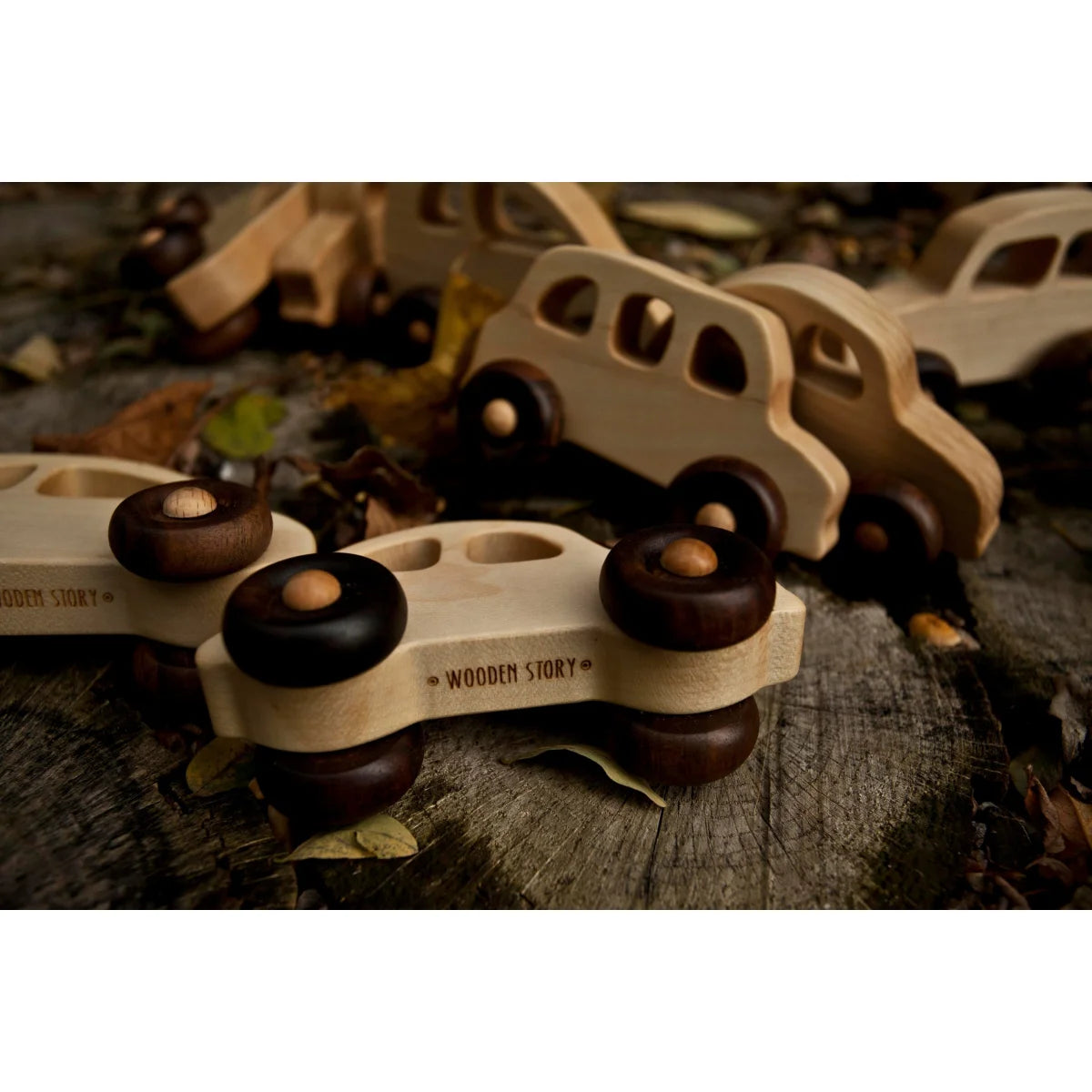 Ein hellfarbenes hölzernes spielzeugbus mit dunkelbraunen runden rädern und wood story gravur als geschenk für neugeborene
