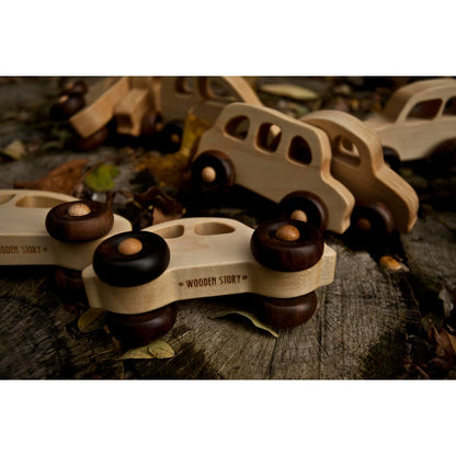 Ein hellfarbenes hölzernes spielzeugbus mit dunkelbraunen runden rädern und wood story gravur als geschenk für neugeborene