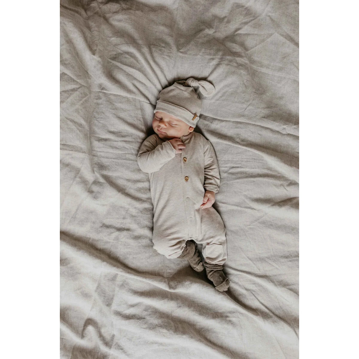 Schlafendes Baby in beigem Outfit, Butt Onesie in Beige