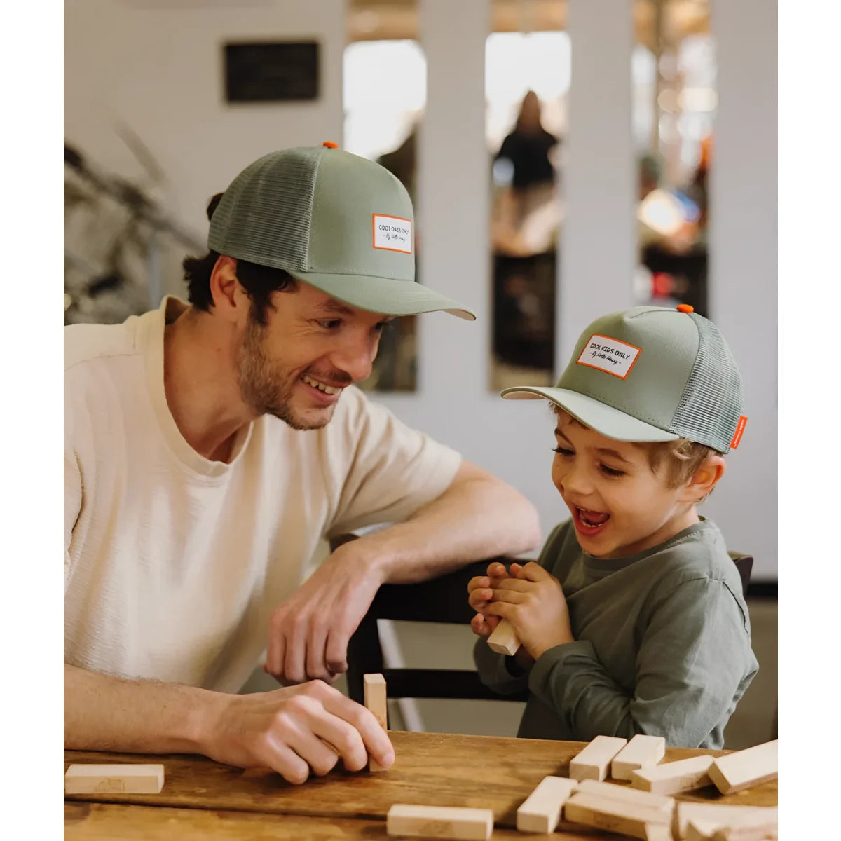 Olive grüne mesh-trucker-kappe mit orangefarbenem knopf und weißem label mit der aufschrift cold wind only