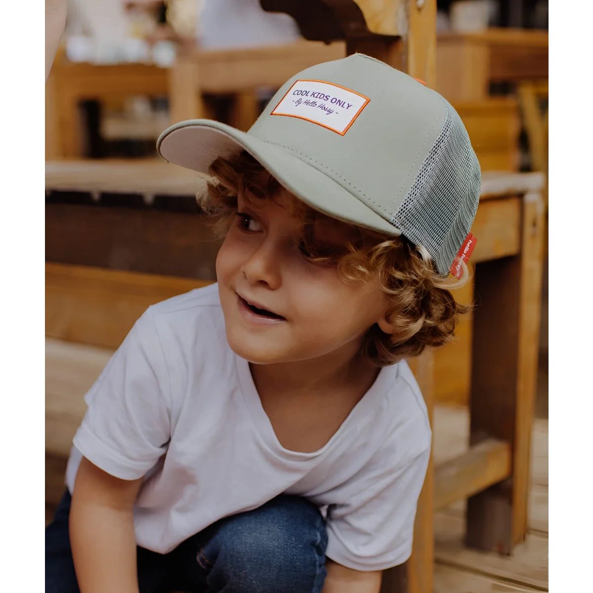 Ein hellgrauer truckerhut mit mesh-rückseite und orange umrandetem patch cool kids only von dale s im modell cap mini olive