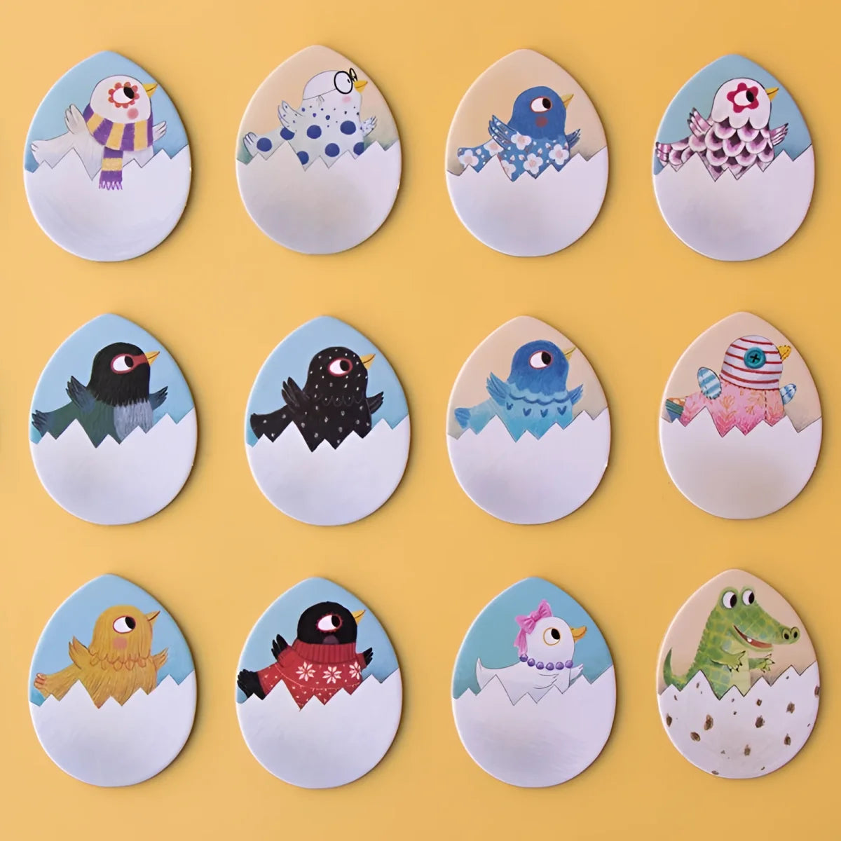 Sammlung von Papiereiern mit schlüpfenden Küken in Winteraccessoires