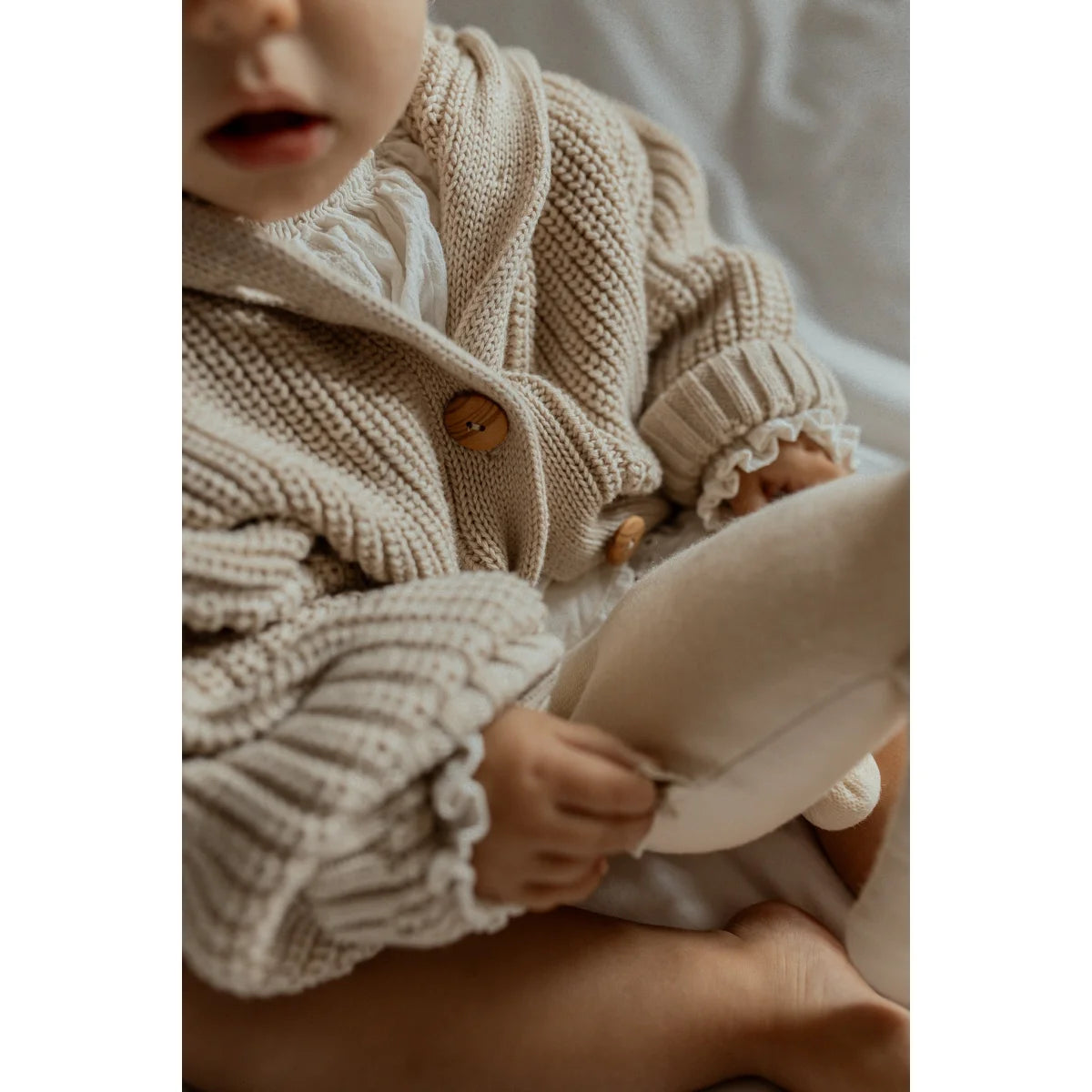 Chunky Strickjacke mit Holzknöpfen, getragen von einem jungen Kind in Oat