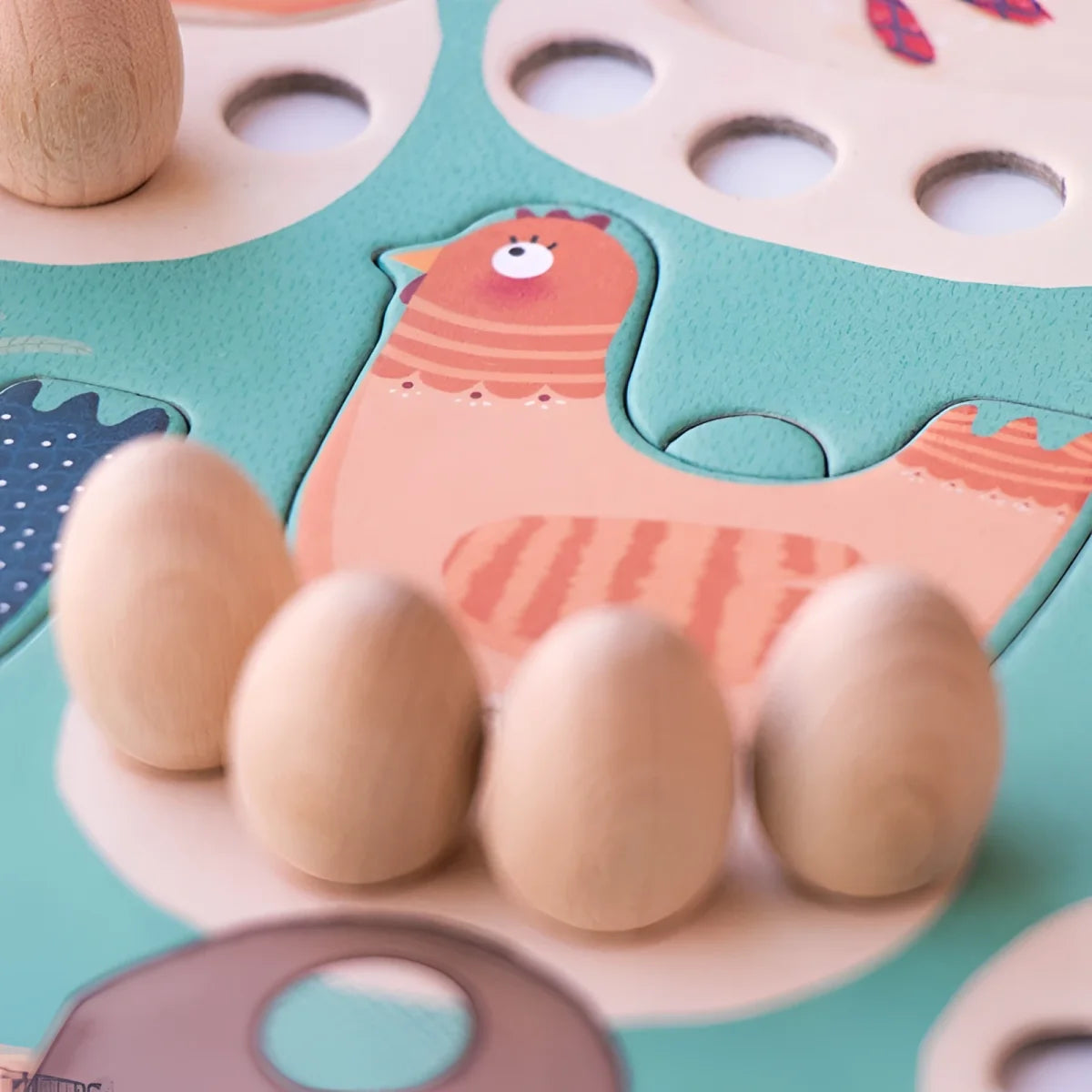 Holzpuzzle in Form eines rosa Huhns mit Eiern vor dem Spiel Cluck, cluck! The Fox!