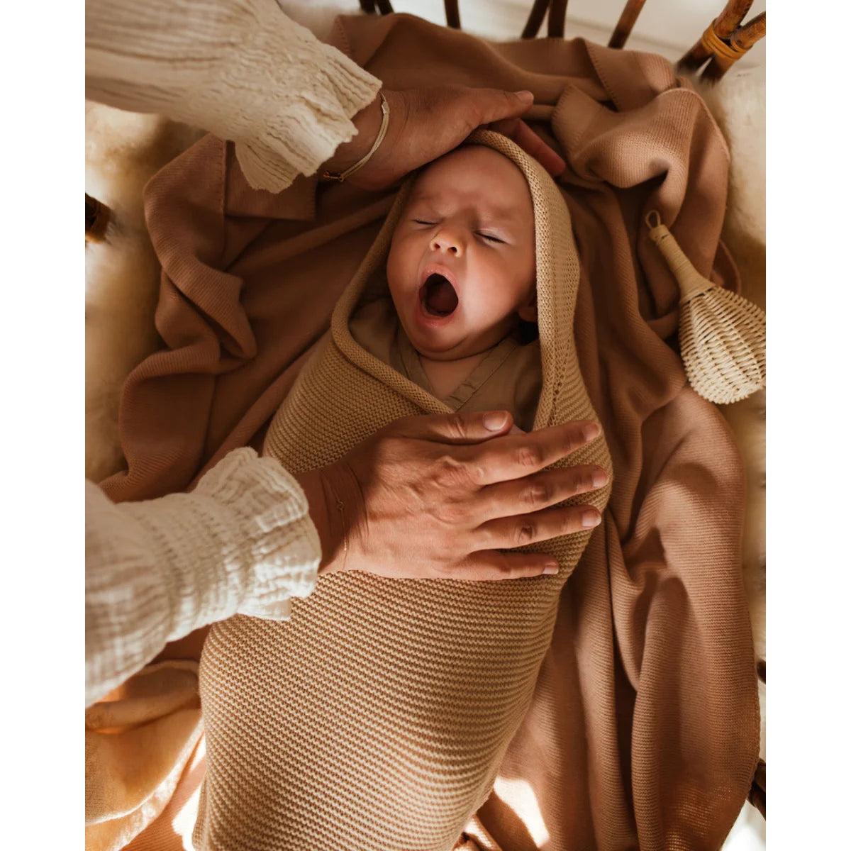 Schlafender neugeborener Säugling gähnt in einer Kuscheldecke Cocoon Babydecke Oat