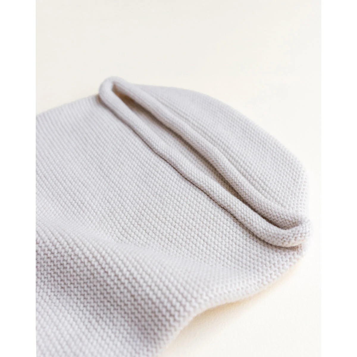Weißes Strick-Beret oder lässige Mütze zum Produkt Cocoon Babydecke in Off-White