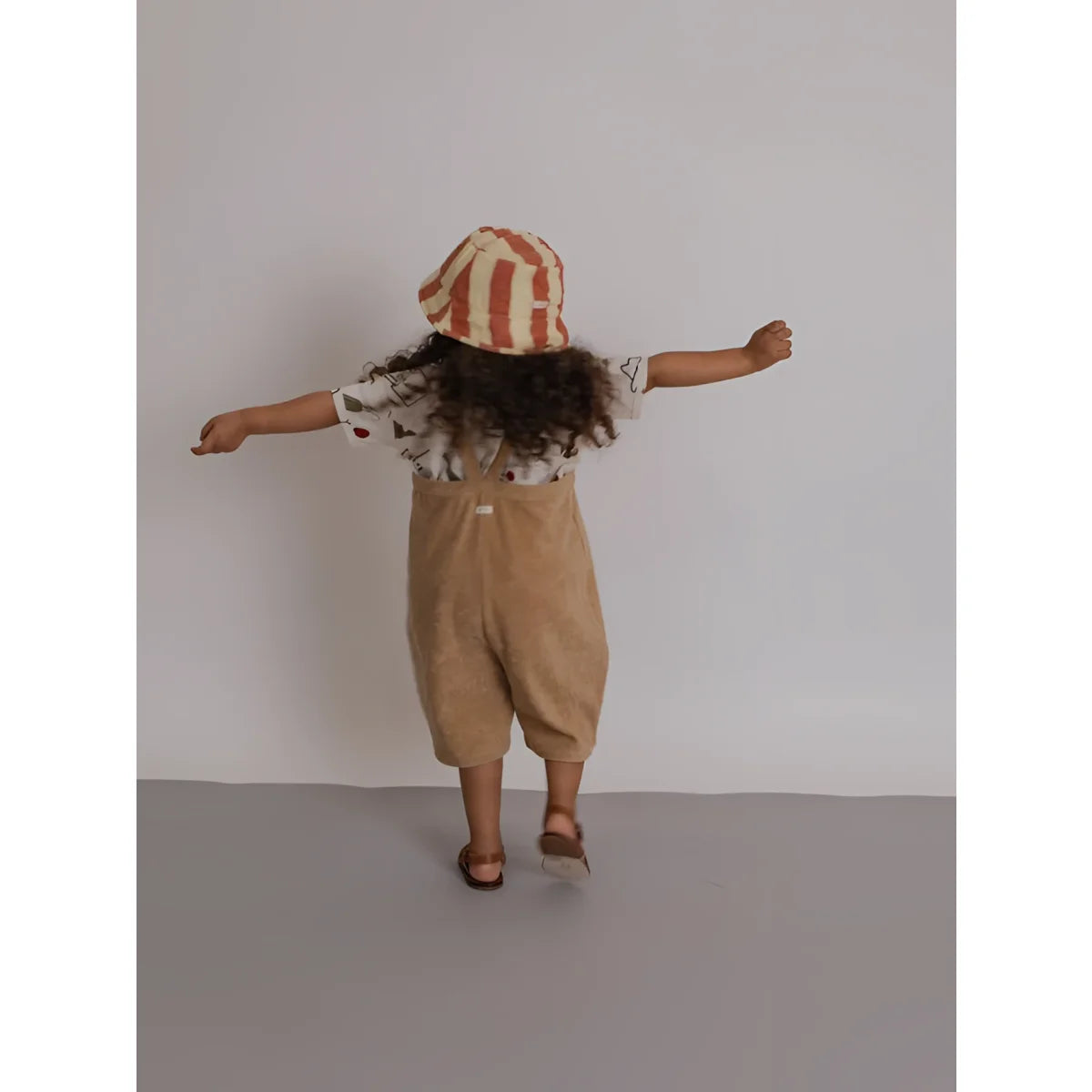 Kind in rot-crem gestreiftem Eimerhut bei Cropped Dungarees Latzhose Terry