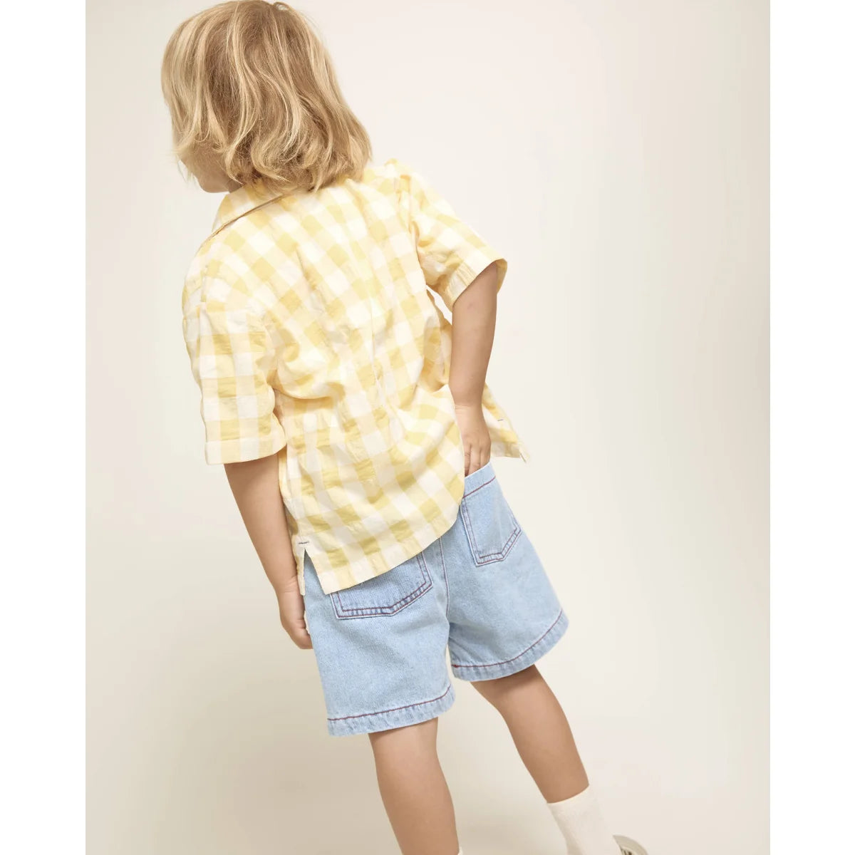 Mädchen in gelb-weißer Karo-Shirt und hellblauer Twill Mädchenhose