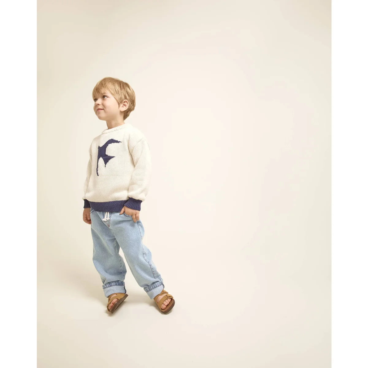 Mädchen in taupe Mädchenhose mit Strickpullover und Vogelmuster