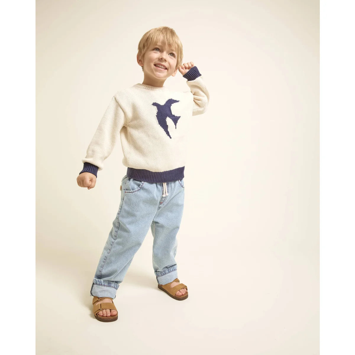 Beige Strickpullover mit blauer Vogel auf taupe Mädchenhose