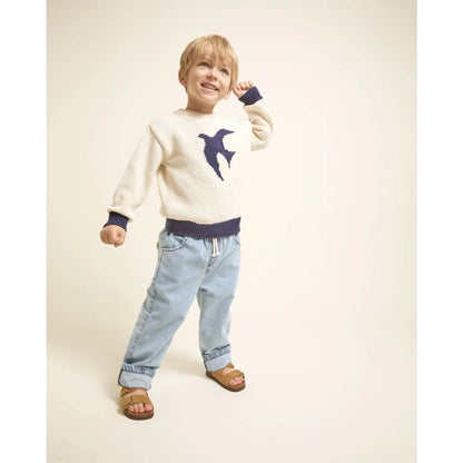 Beige Strickpullover mit blauer Vogel auf taupe Mädchenhose