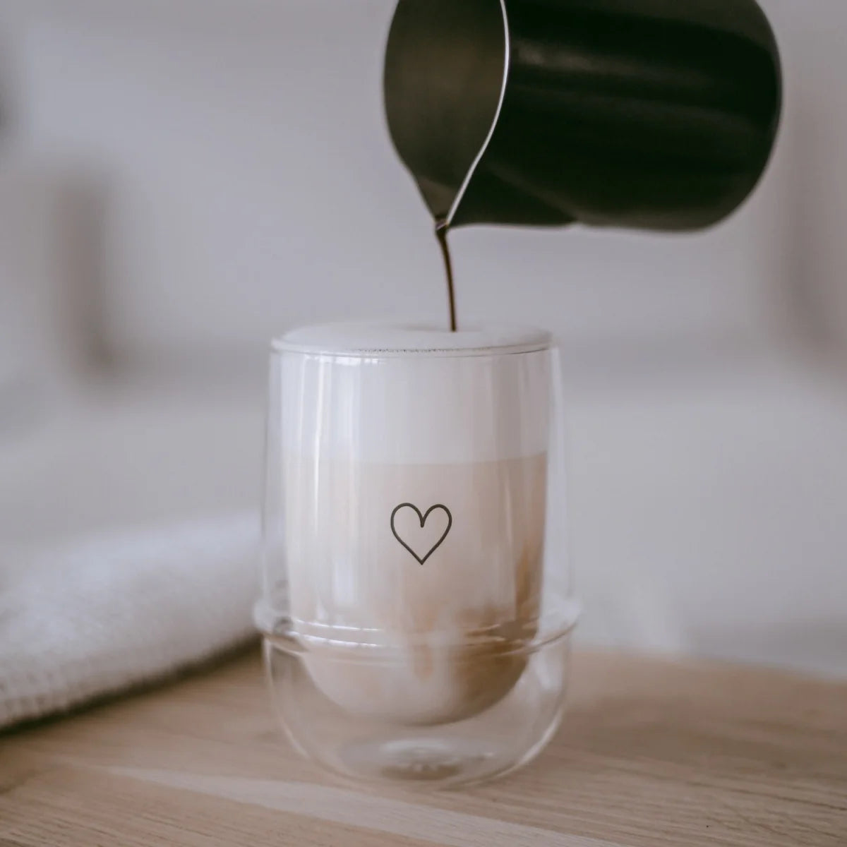 Doppelwandiges Glas Herz mit schwarzem Herz-Design, gefüllt mit Latte Macchiato