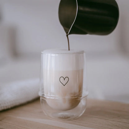 Doppelwandiges Glas Herz mit schwarzem Herz-Design, gefüllt mit Latte Macchiato