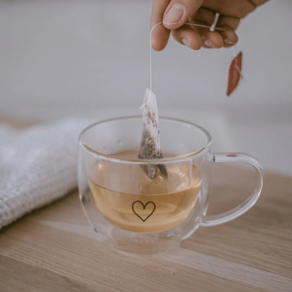 Doppelwandige Glastasse Herz 250ml mit Herz-Design, gefüllt mit Tee und Teesbeutel