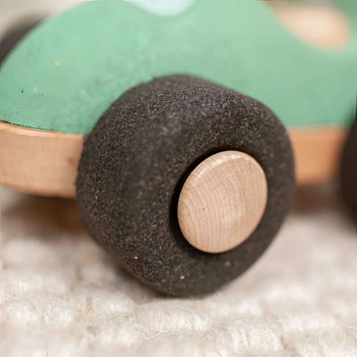 Holzrad eines Spielzeugs, Teil des E-Cork Racer Fahrzeugs in Grün