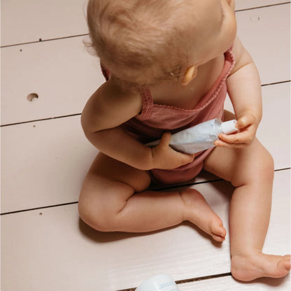 Baby hält eine Tube Lotion für sanfte Hautpflege im Produkt Gentle Cream 100ml
