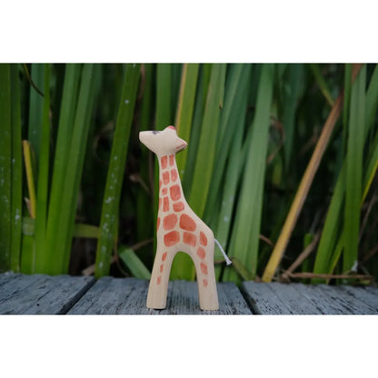 Holzige Spielzeuggiraffe mit orangefarbenen Flecken für das Produkt Giraffe klein