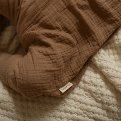 Weicher, strukturierter Stoffdecke in warmem Braun, passend zum Harem Romper beige