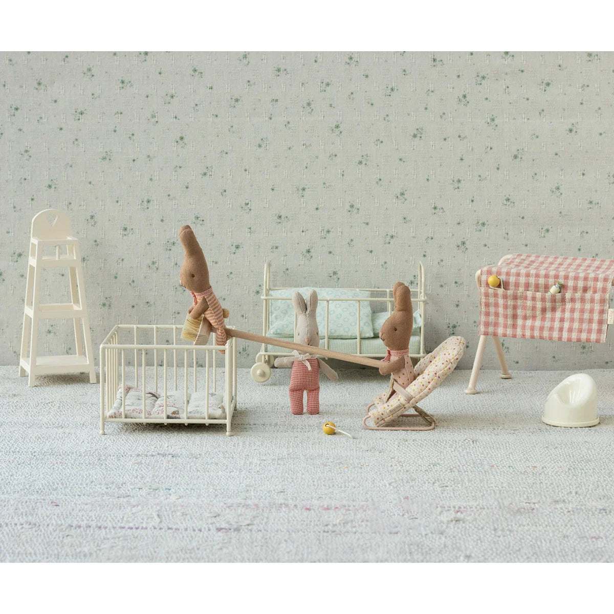 Miniatur wippe aus holz mit zwei plüschhasen in rot karierten outfits für ökologische baby- & kinderprodukte