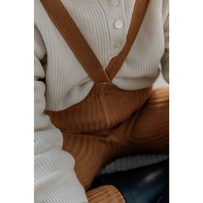 Braune Corduroy-Latzhose über einem weißen Strickpullover, Hippy Footed Strumpfhosen mit Träger