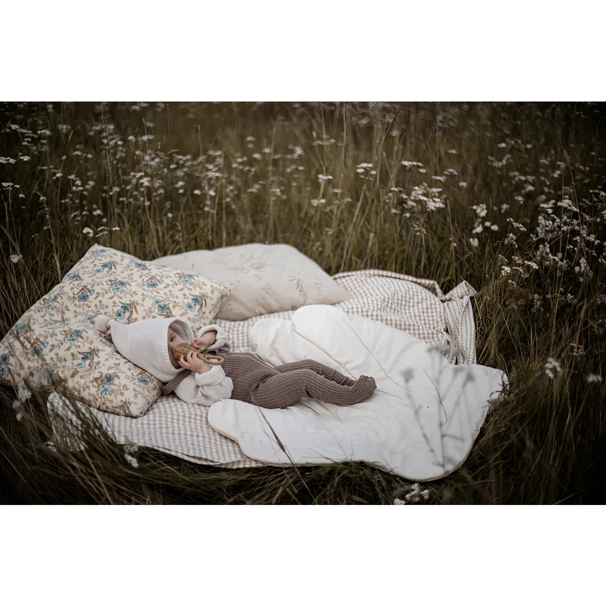 Baby liegt auf einer Decke mit Kissen in Hippy Footed Strumpfhosen mit Träger Cocoa Blend