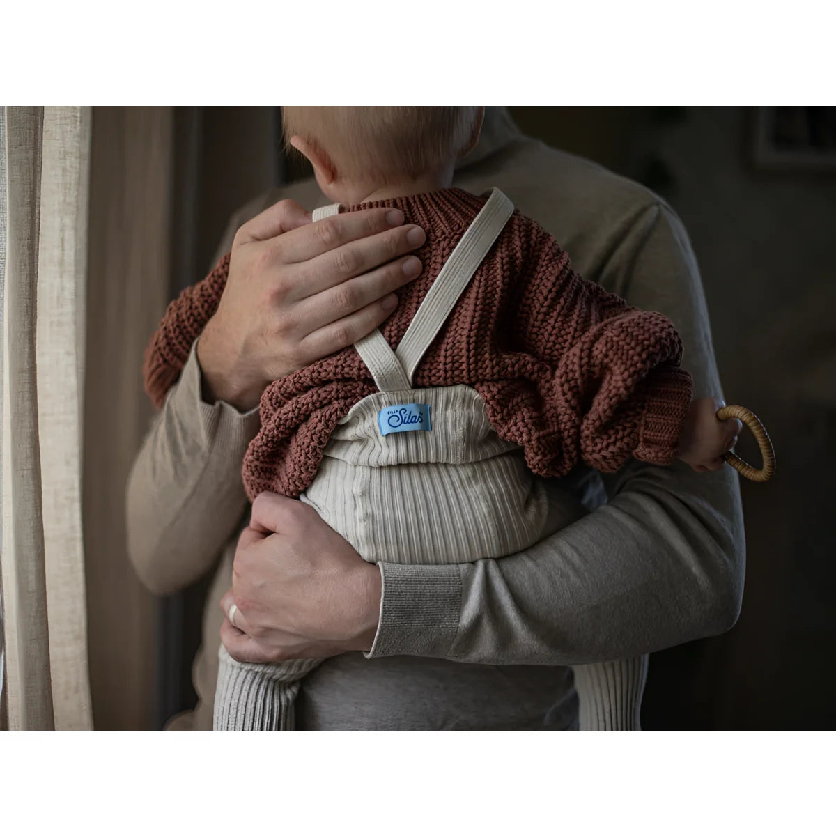 Baby in einer gestrickten Decke, eng an Brust gehalten, für Hippy Footed Strumpfhosen