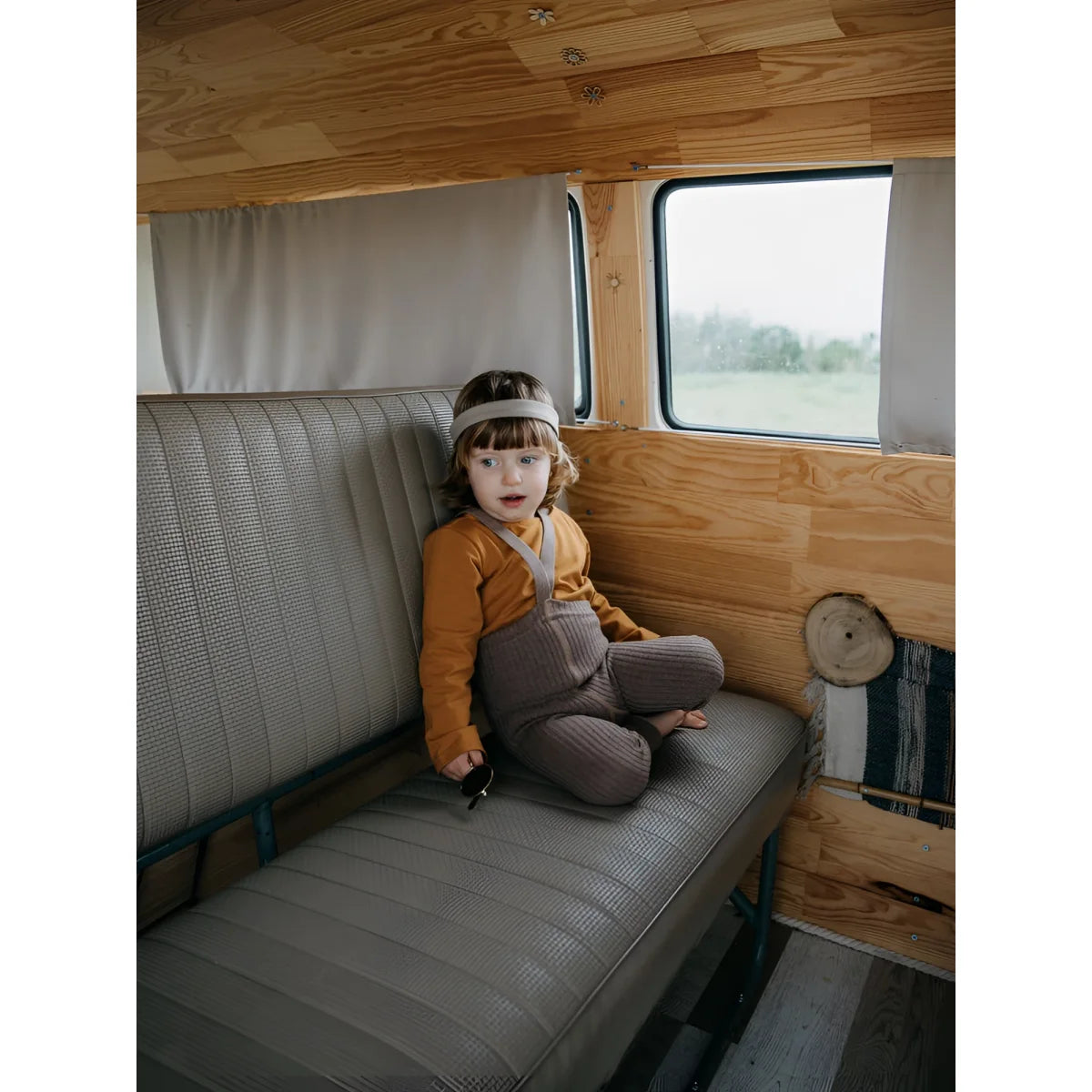 Kind sitzt auf einer Bank in einem Campervan mit Hippy Footless Strumpfhosen