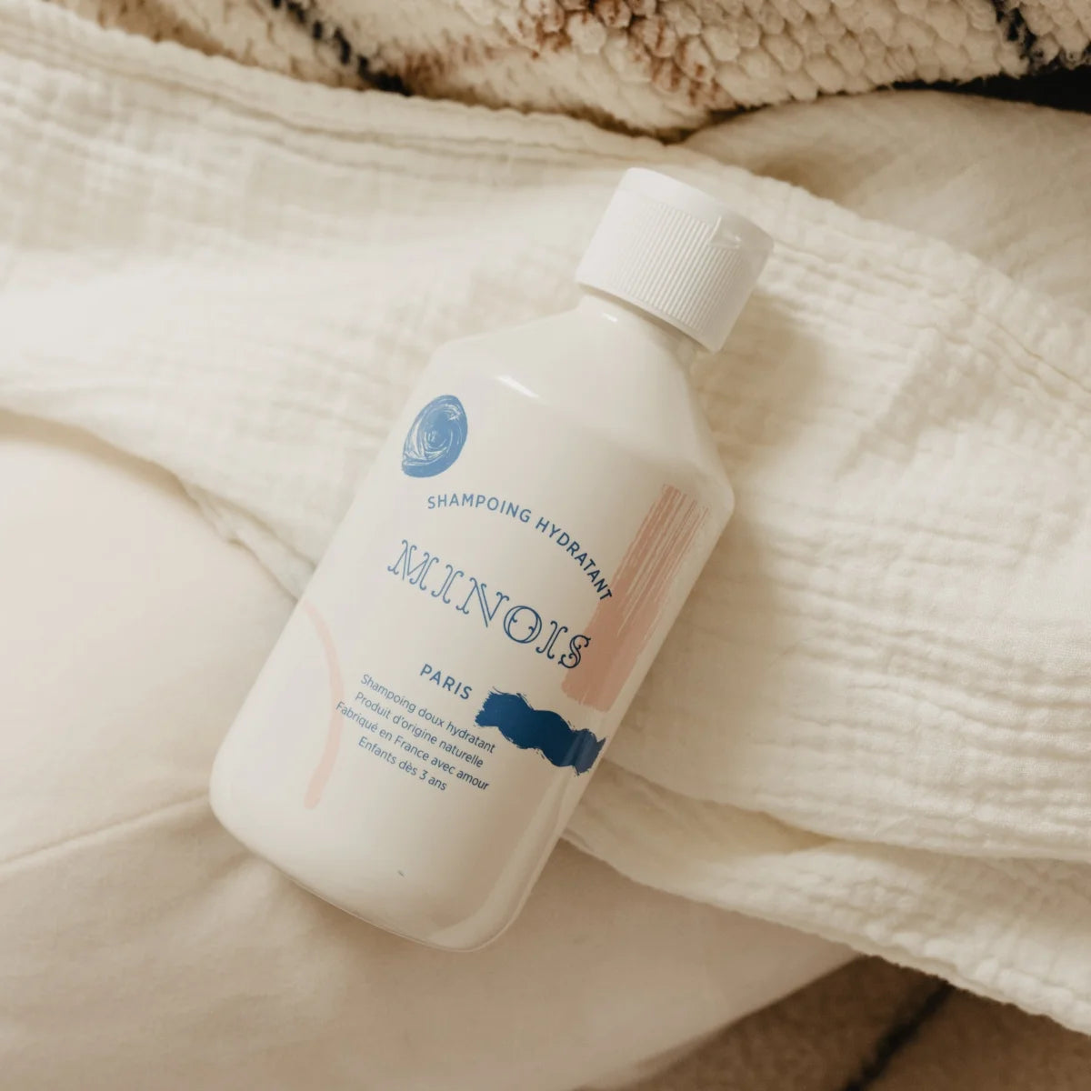 Weiße plastikflasche minois paris hydrating shampoo 300 ml mit blauem und pinkem abstraktem etikettdesign