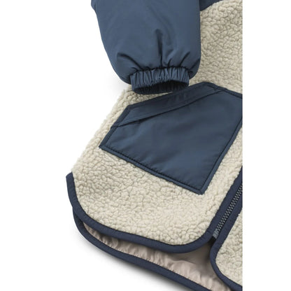 Creamfarbene sherpa-gefütterte jacket runa mit navyblauen nylonärmeln und passender fronttasche in mist classic navy