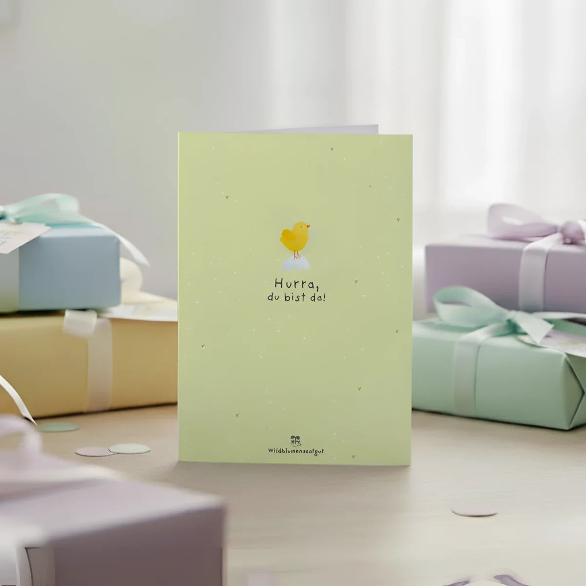 Pale green greeting card with yellow chick illustration and black text hurra du bist da perfect for newborn wishes