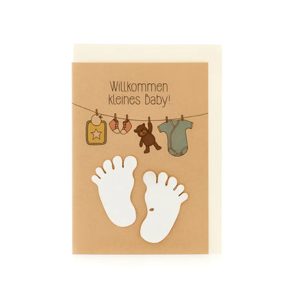 Karte Willkommen kleines Baby: beige Babykarte mit weissen Babyfüssen und illustrativem Kleiderbügel
