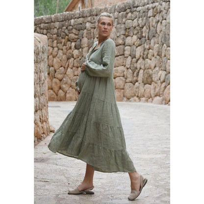 Ein fließendes olivegrünes stufenkleid aus leinen mit langen ärmeln ideal für nachhaltige babykleidung schweiz