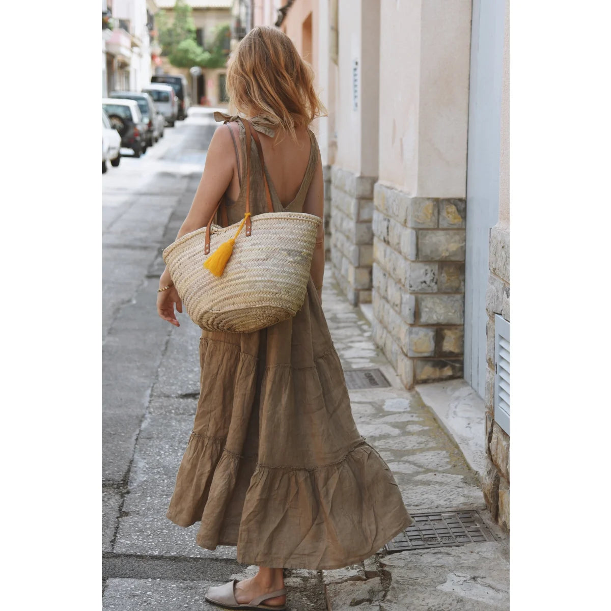 Frau in braunem gestreiftem Kleid mit Strohtasche bei Kleid Sevilla Rye