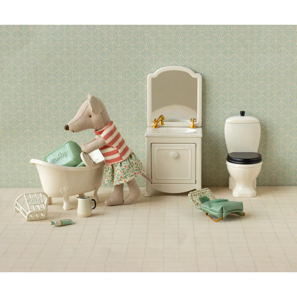 Ein plüsch maus-figürchen mit kleidungsset in rot-weiß gestreift und blumenrock neben mini badewanne geschenke