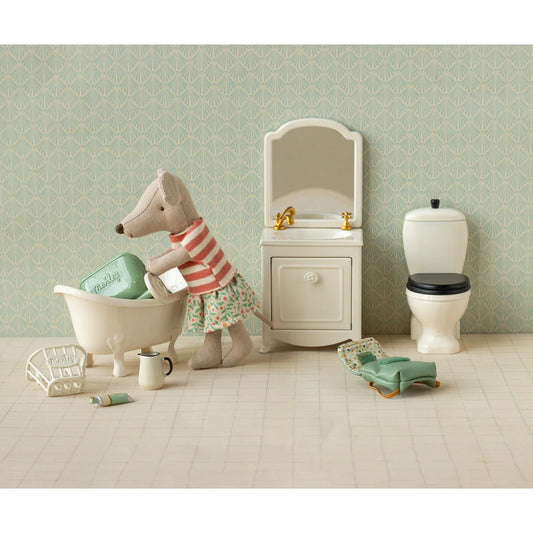 Ein plüsch maus-figürchen mit kleidungsset in rot-weiß gestreift und blumenrock neben mini badewanne geschenke