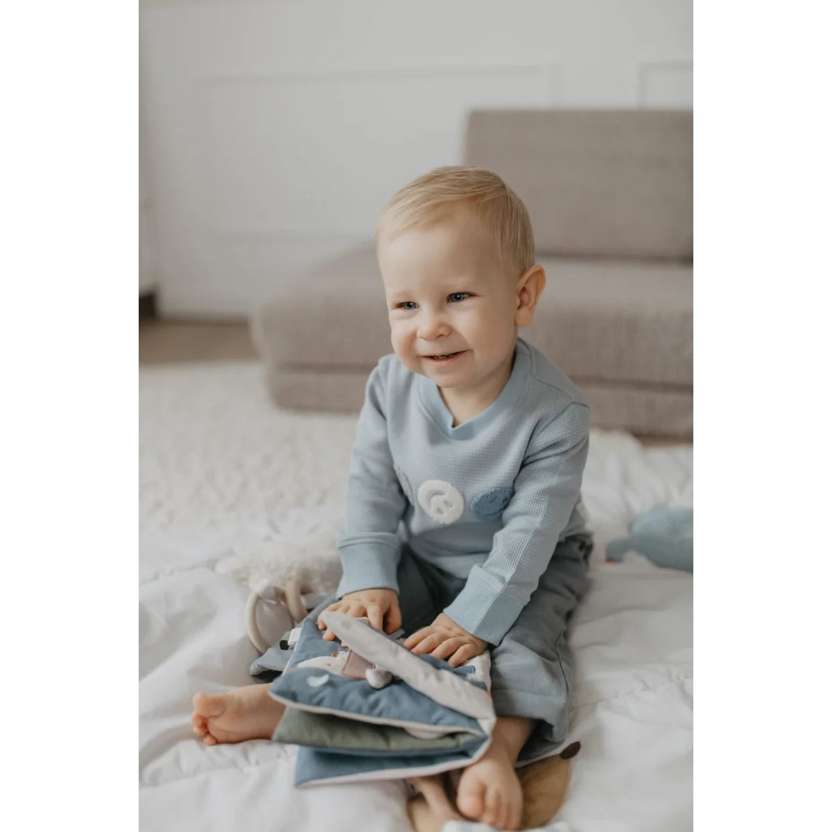 Knisterbuch hund aus softem hellblauem samtstoff mit lächelndem gesicht ideal für ökologische baby- & kinderprodukte