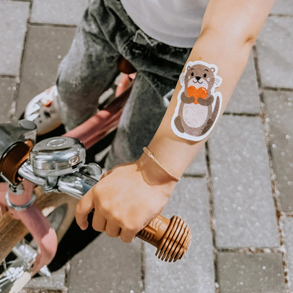 Ein charmanter brauner otter hydrogel tattoo mit weißer kontur und orangefarbener schleife für kühlende pflaster