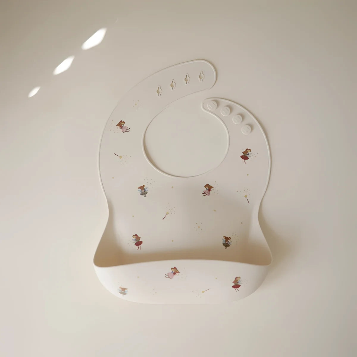 Weißes silikonlätzchen mit feinem muster winziger feeillustrationen nachhaltige babykleidung schweiz geschenke