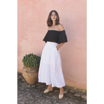 Frau in schwarzem Off-Shoulder-Top und weißem Rock, Produkt Leinen Rock Alba Blanco