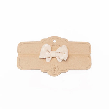 Beigefarbene Stoffschleife auf einem dekorativen Holzschild für Little Bow Haarband