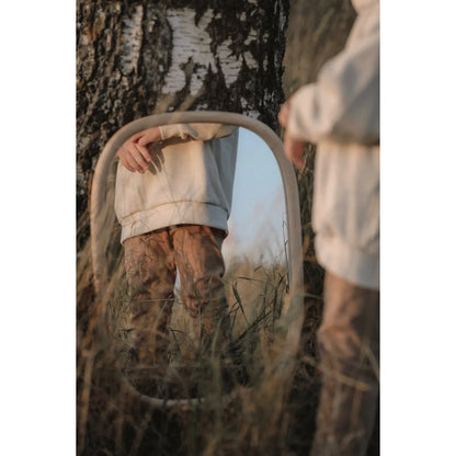 Oval mirror in tall grass and foliage enhancing Loose fit Pants by Kakao