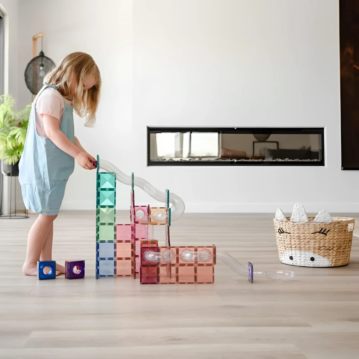 Kind spielt mit bunten Magnetbausteinen auf dem Boden des Magnetbausteine Sets