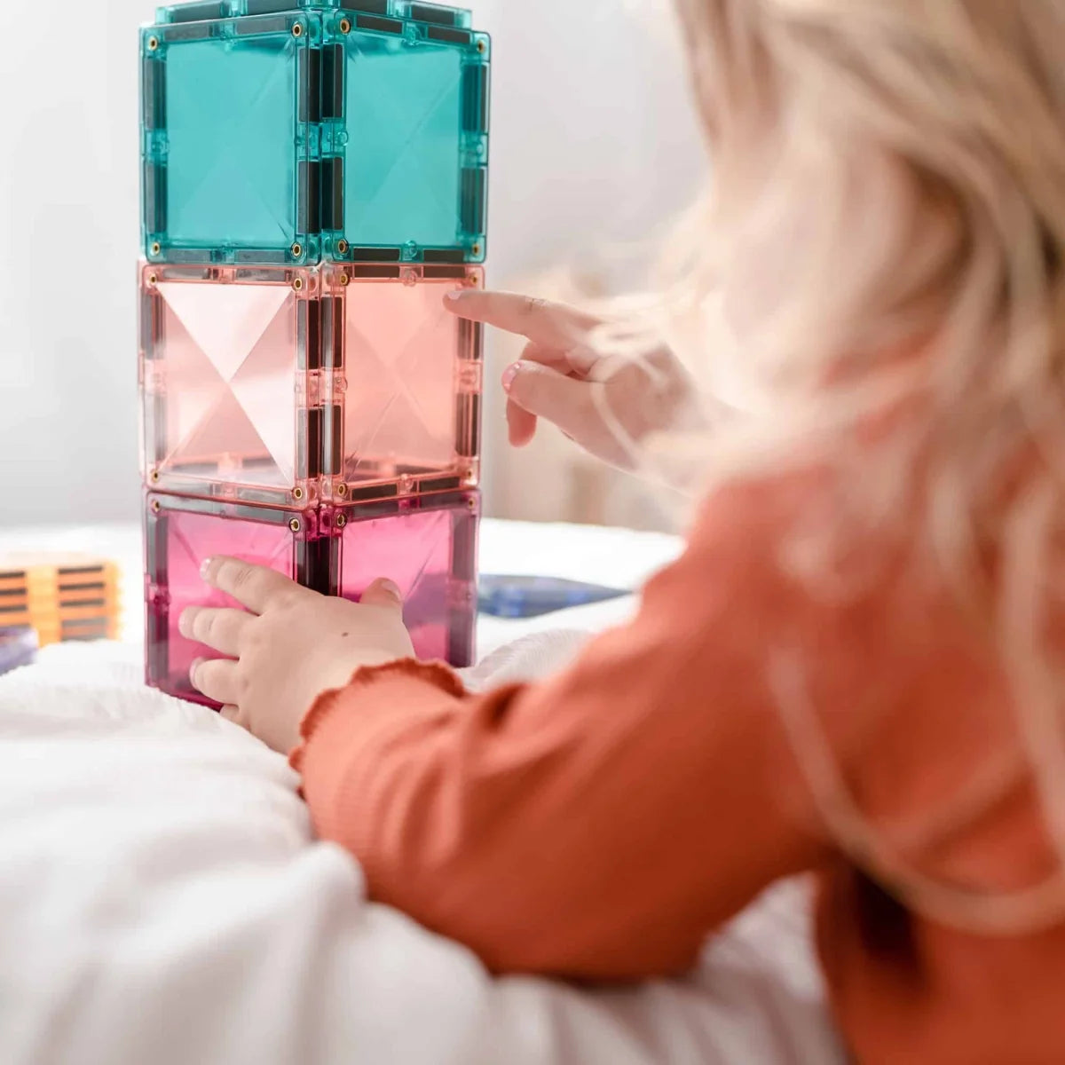 Bunte Magnetbausteine werden von kleinen Händen zum Spielen verwendet