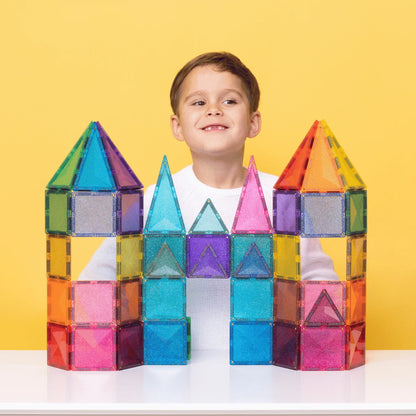 Junger Junge hinter einer bunten Magnetbausteine Glitter Castle Pack 48 stk