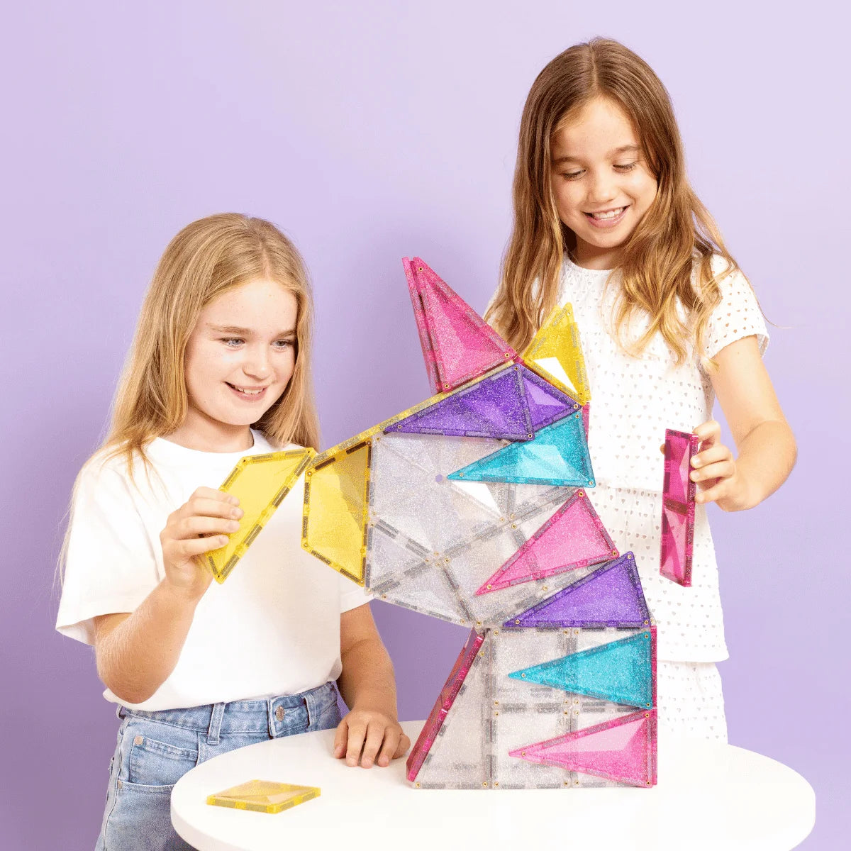 Zwei junge Mädchen bauen eine bunte Magnetbausteine Glitter Unicorn Pack 56 Stk