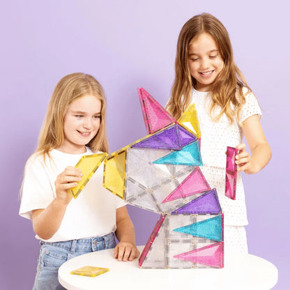 Zwei junge Mädchen bauen eine bunte Magnetbausteine Glitter Unicorn Pack 56 Stk