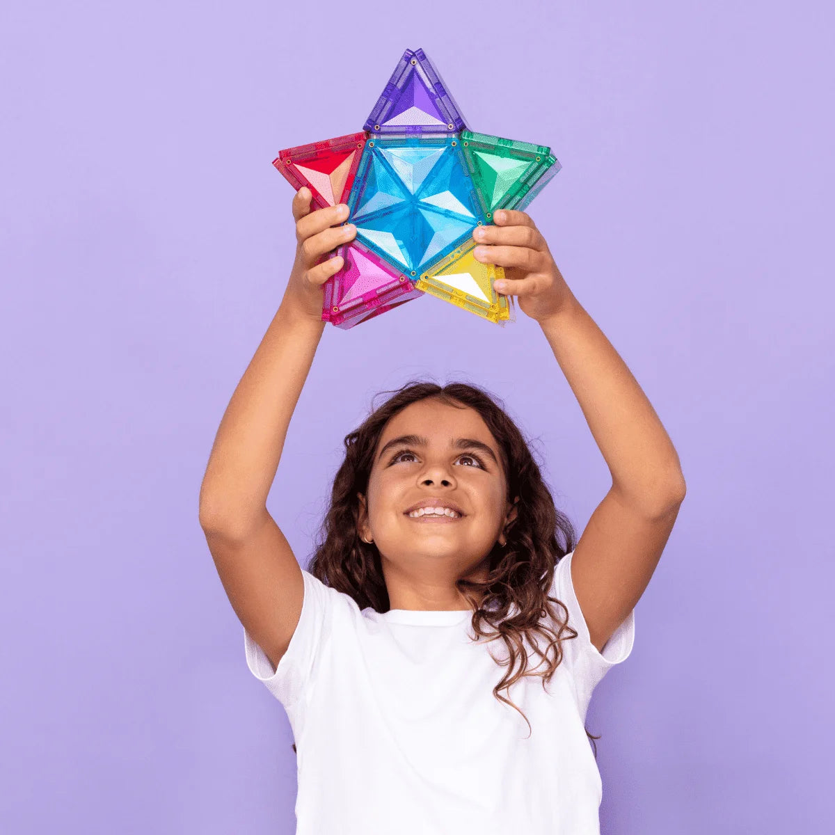 Lächelndes Kind hält bunte Magnetstern-Spielzeug aus Magnetbausteine Light Star Pack