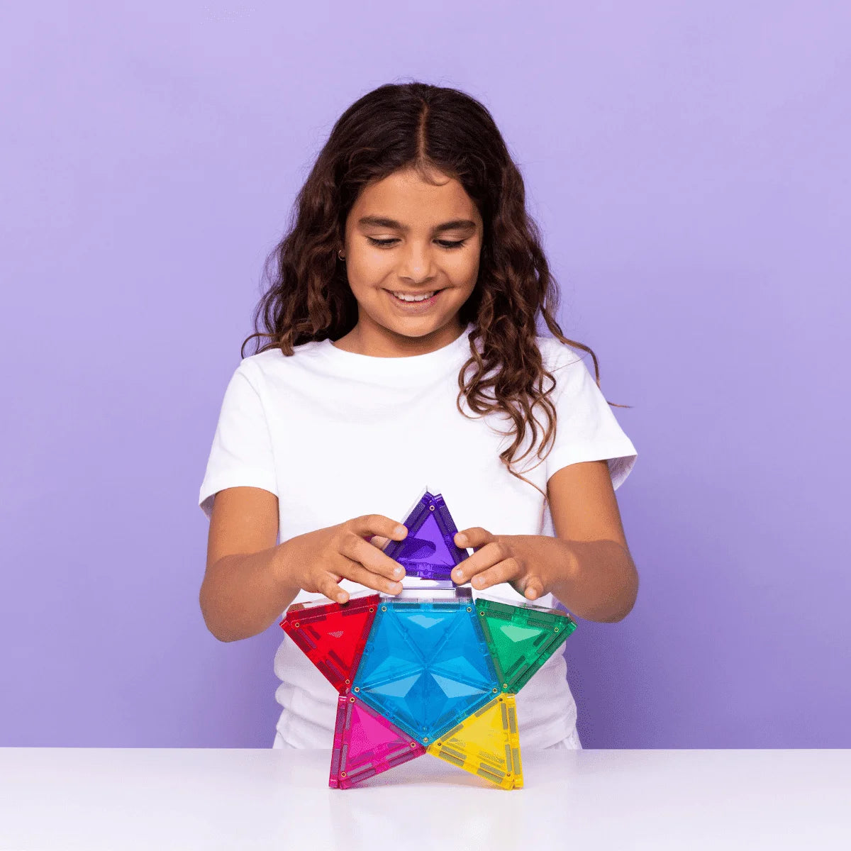 Junge Mädchen beim Zusammenbauen eines bunten Magnetbaustein-Sterns im Light Star Pack