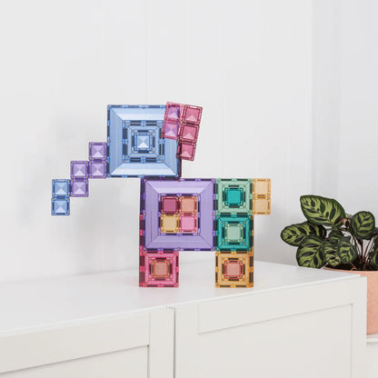 Ein buntes, durchsichtiges magnetbausteine set in pastellfarben blau, lila, rosa und grün als einhorn geformt