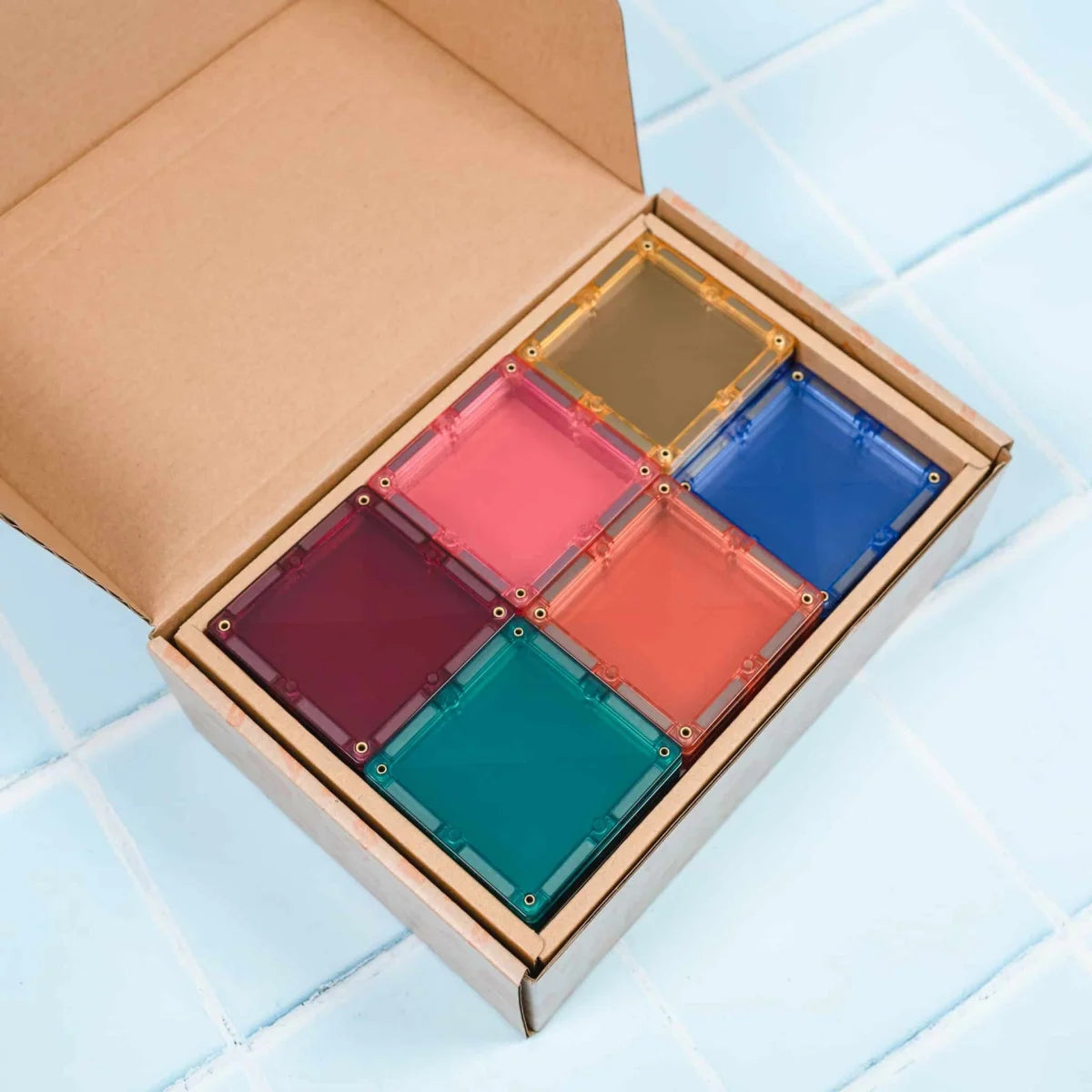 Set aus sechs durchsichtigen, bunten magnetischen Bausteinen in Pastellfarben im Karton Verpackung